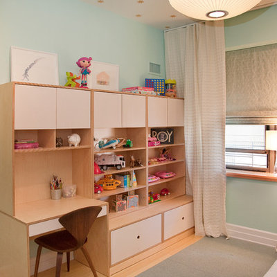 Trendy gender-neutral light wood floor kids' room photo in New York with blue walls