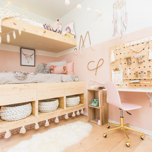 Immagine di una cameretta da bambina scandinava con parquet chiaro e pareti multicolore