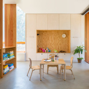 Example of a trendy concrete floor and gray floor kids' room design in Los Angeles with white walls