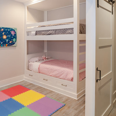 Kids' room - mid-sized transitional girl light wood floor kids' room idea in New York with pink walls