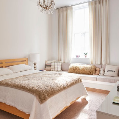 Example of a trendy girl brown floor and medium tone wood floor kids' bedroom design in New York with white walls