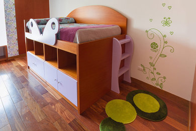 Imagen de habitación de niña de 4 a 10 años moderna con paredes blancas y suelo de madera en tonos medios