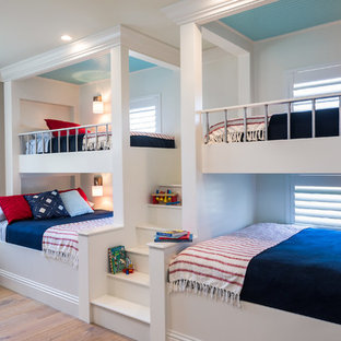 Cette image montre une très grand chambre d'enfant marine avec un sol en bois brun, un sol marron et un mur gris.