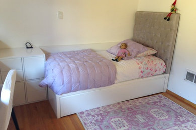 Foto de dormitorio infantil de 4 a 10 años actual de tamaño medio con suelo de madera en tonos medios y paredes blancas