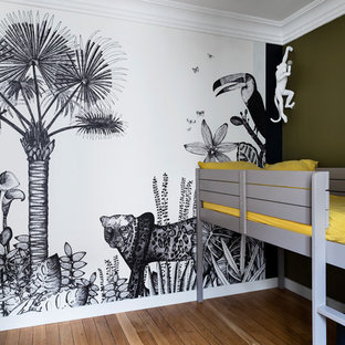 Aménagement d'une chambre d'enfant de 4 à 10 ans contemporaine de taille moyenne avec un mur multicolore et un sol en bois clair.