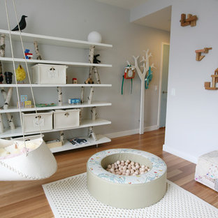 Mid-sized danish gender-neutral light wood floor kids' room photo in New York with gray walls