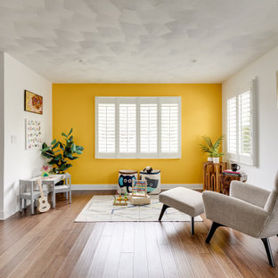 Transitional gender-neutral medium tone wood floor and brown floor kids' room photo in Los Angeles with yellow walls