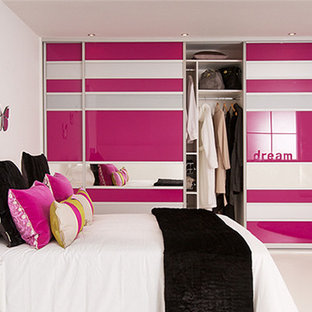 Esempio di una piccola cameretta per bambini moderna con pareti rosa e parquet chiaro