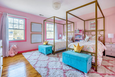 Ejemplo de dormitorio infantil contemporáneo con paredes rosas, suelo de madera en tonos medios y suelo marrón