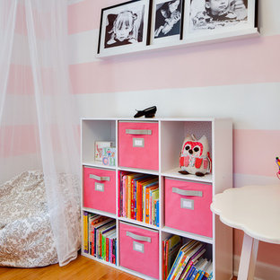 Trendy girl medium tone wood floor kids' room photo in Minneapolis with multicolored walls