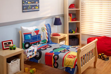 Diseño de habitación de niño de 1 a 3 años con paredes grises y suelo de madera en tonos medios