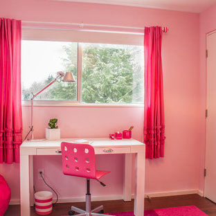 Immagine di una cameretta per bambini da 4 a 10 anni moderna di medie dimensioni con pareti rosa e parquet scuro
