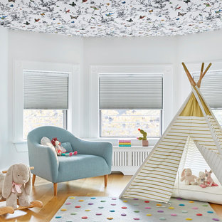 Esempio di una grande cameretta per bambini da 1 a 3 anni tradizionale con pareti bianche, parquet chiaro e pavimento marrone