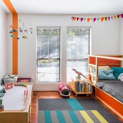 Kids' room - mid-century modern gender-neutral medium tone wood floor kids' room idea in Austin with multicolored walls