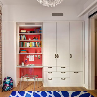 Cette image montre une petit chambre neutre de 4 à 10 ans urbaine avec un bureau, un mur rouge et un sol en bois clair.