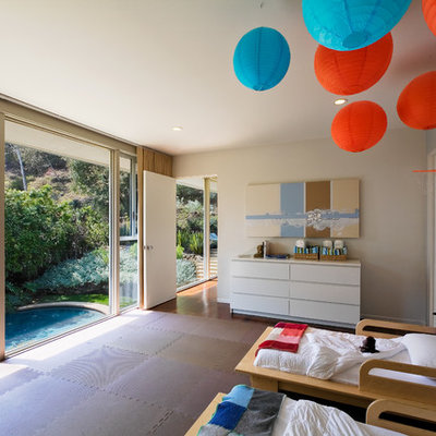 Example of a mid-century modern gender-neutral kids' room design in Los Angeles with gray walls