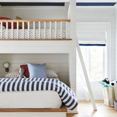 Beach style gender-neutral light wood floor kids' room photo in Dallas with white walls