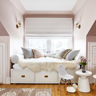 Inspiration for a large transitional girl medium tone wood floor and brown floor kids' room remodel in Los Angeles with pink walls