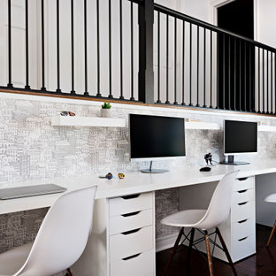 Cette image montre une chambre d'enfant traditionnelle avec un bureau, un mur multicolore, un sol en bois foncé et du papier peint.