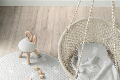 Photo of a small scandinavian gender neutral toddler’s room in Melbourne with white walls and light hardwood flooring.