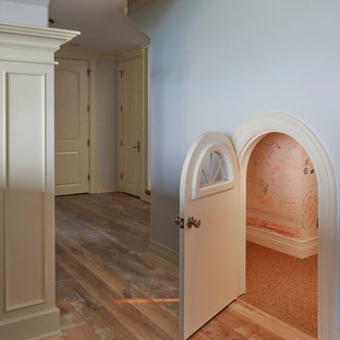 Esempio di una cameretta per bambini da 4 a 10 anni mediterranea di medie dimensioni con pareti beige, pavimento in laminato e pavimento marrone