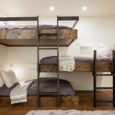 Trendy gender-neutral dark wood floor kids' room photo in Orange County with white walls