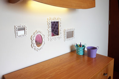 Ejemplo de dormitorio infantil de 4 a 10 años minimalista con paredes blancas y suelo de madera en tonos medios