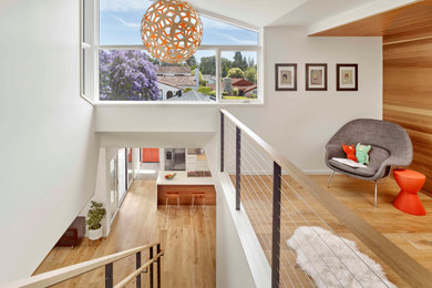 Example of a small minimalist gender-neutral medium tone wood floor and brown floor kids' room design in San Francisco with white walls