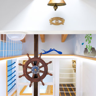 Idee per una grande cameretta per bambini da 4 a 10 anni stile marino con pareti blu e parquet chiaro