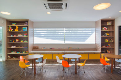 Imagen de dormitorio infantil de 4 a 10 años moderno grande con paredes blancas y suelo de madera en tonos medios