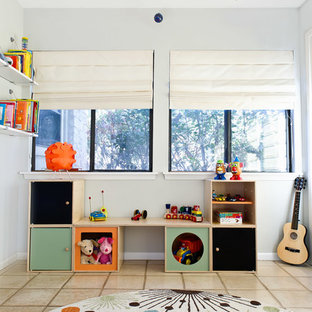 Cette image montre une chambre d'enfant design de taille moyenne avec un mur blanc et un sol en travertin.