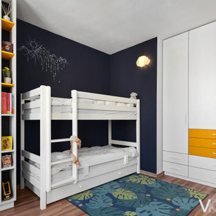 Idee per una cameretta per bambini da 4 a 10 anni moderna di medie dimensioni con pareti blu, pavimento in laminato e pavimento marrone