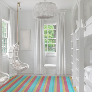 Immagine di una cameretta per bambini stile marino con pareti bianche e pavimento in legno verniciato
