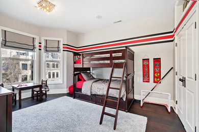 Large classic children’s room for boys in Chicago with grey walls, dark hardwood flooring and brown floors.