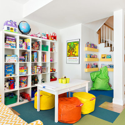 Elegant gender-neutral light wood floor kids' room photo in New York with white walls