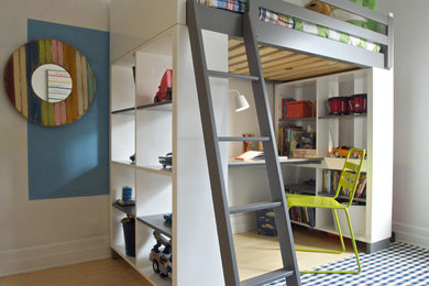 Example of a trendy gender-neutral light wood floor and beige floor kids' study room design in New York with white walls