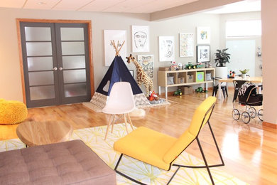 Diseño de dormitorio infantil moderno de tamaño medio con paredes beige y suelo de madera clara