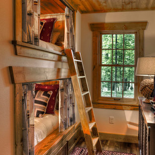 Idée de décoration pour une chambre d'enfant chalet avec un mur beige et un sol en bois foncé.