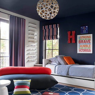 Immagine di una cameretta per bambini design con pareti blu e parquet chiaro