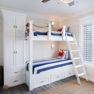 Inspiration pour une chambre d'enfant marine avec un mur beige et un sol en bois foncé.