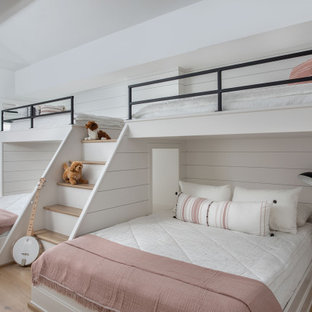 Esempio di un'ampia cameretta per bambini classica con pareti bianche, parquet chiaro, pavimento marrone, soffitto a volta e pareti in perlinato