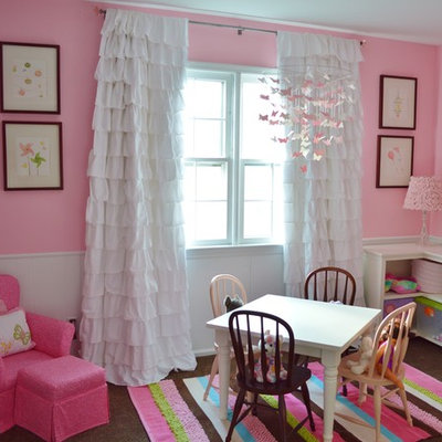 Mid-sized elegant girl dark wood floor kids' room photo in New York with pink walls