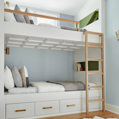 Example of a beach style medium tone wood floor and brown floor kids' bedroom design in Chicago with blue walls