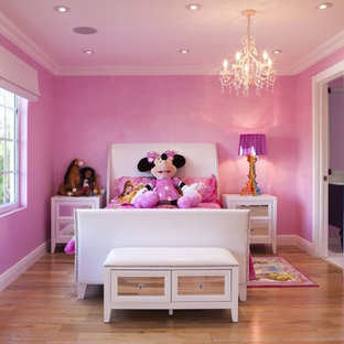 Esempio di una cameretta per bambini da 4 a 10 anni chic di medie dimensioni con parquet chiaro e pareti rosa