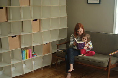 Foto di una piccola cameretta per bambini minimalista con pareti beige e pavimento in legno massello medio