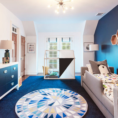 Large transitional boy medium tone wood floor and brown floor kids' room photo in Newark with blue walls