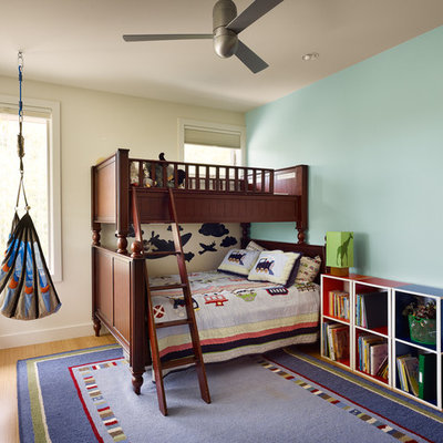 Transitional boy medium tone wood floor kids' room photo in Austin with blue walls