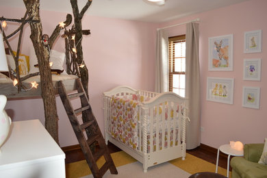 Design ideas for a small romantic toddler’s room for girls in Chicago with pink walls.
