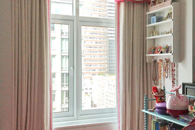 Small traditional playroom for girls in New York with beige walls and pink floors.