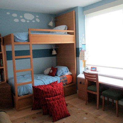 Small elegant boy light wood floor kids' bedroom photo in New York with blue walls